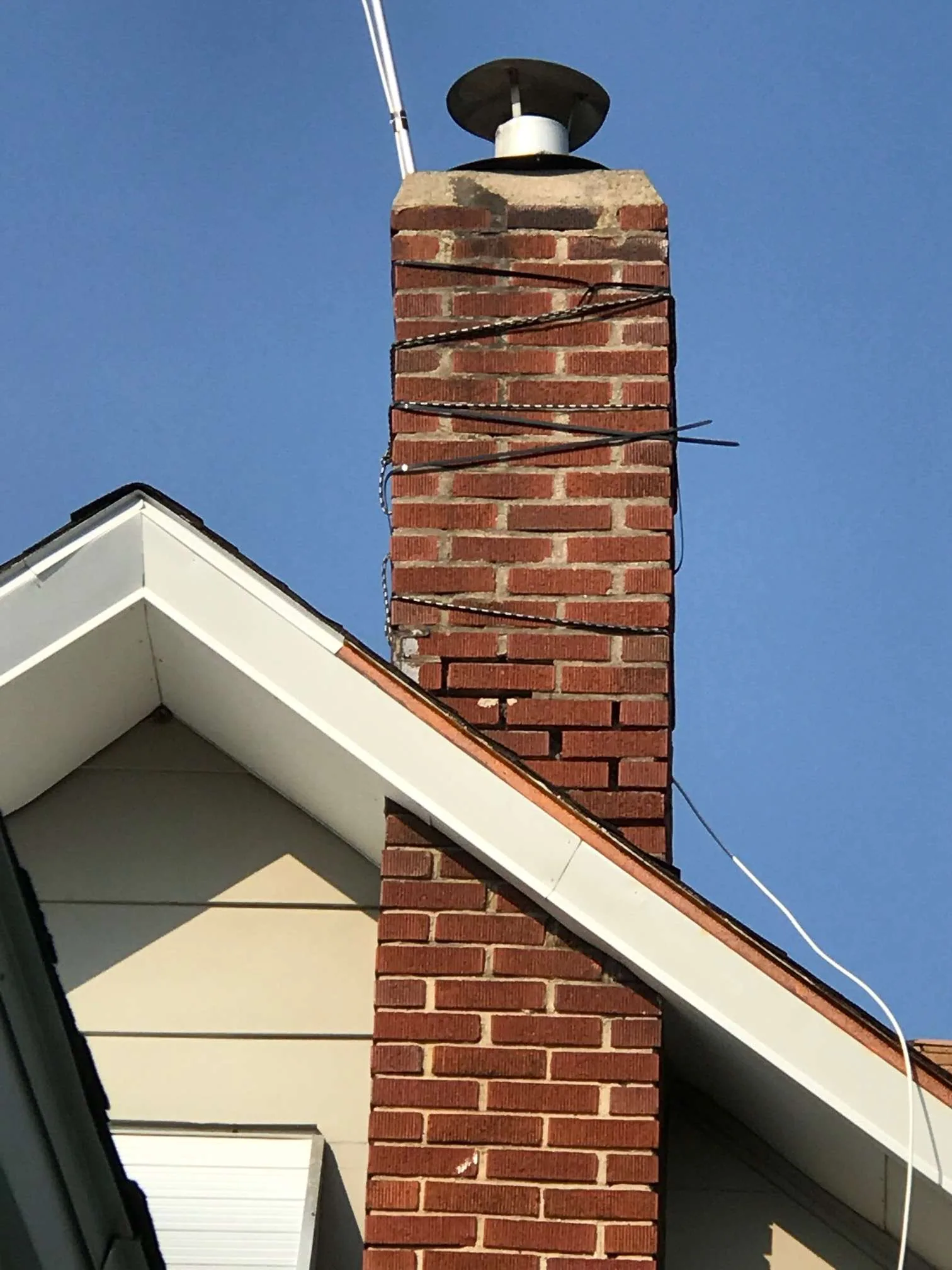 Brick chimney wire strapping damaged mortar