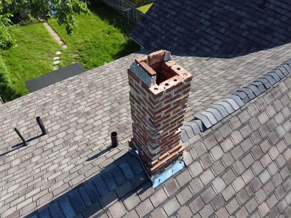 Deteriorated brick chimney rooftop view missing cap