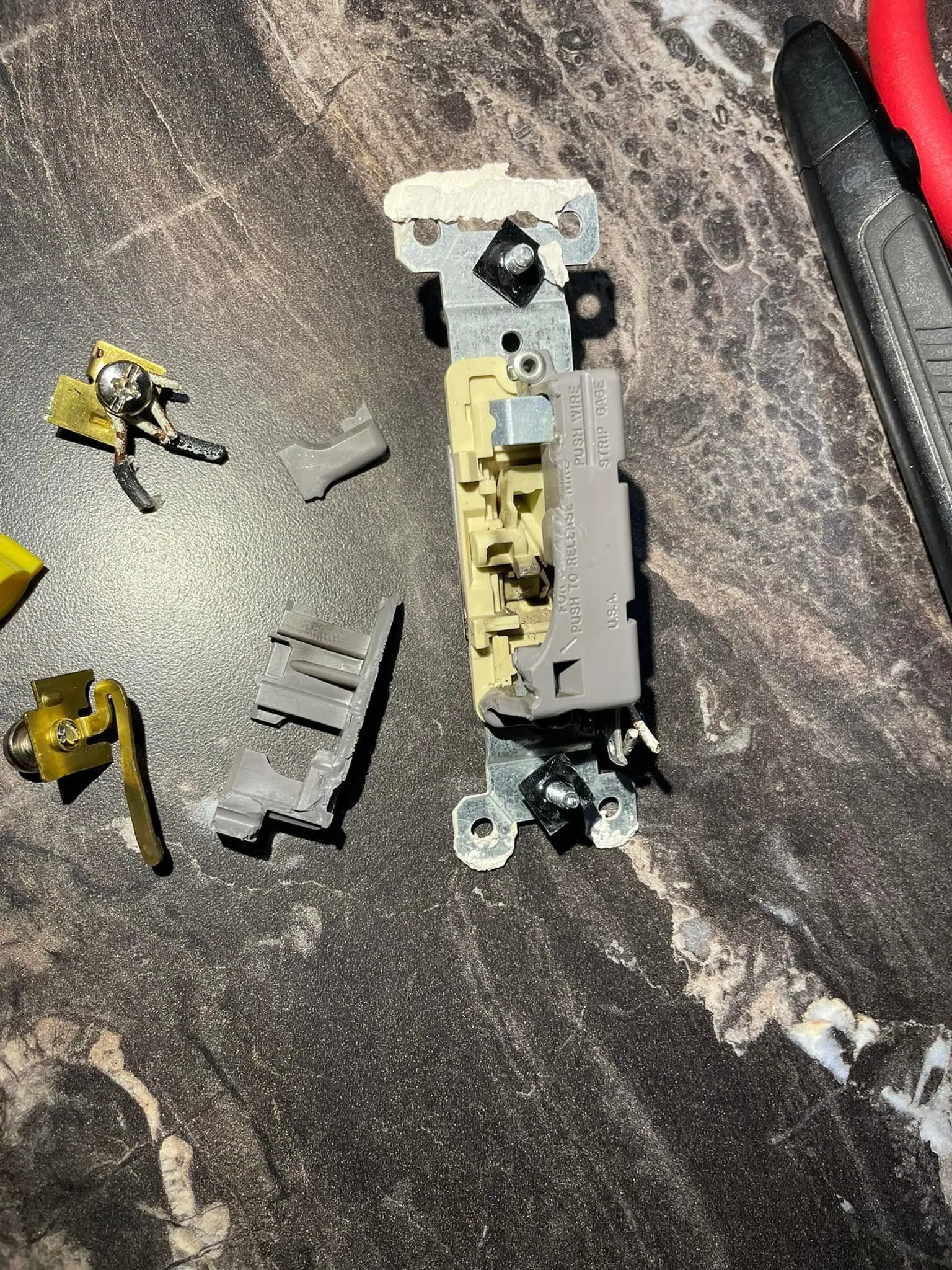 Disassembled light switch broken housing brass contacts countertop
