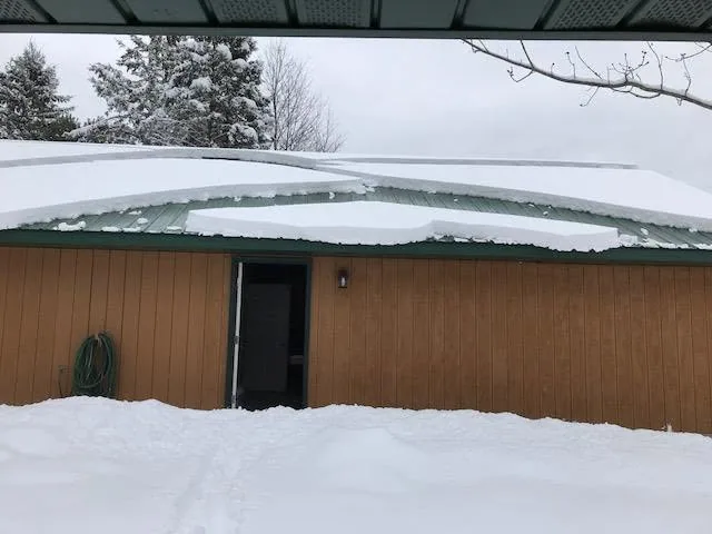 Heavy snow load green metal roof outbuilding open doorway