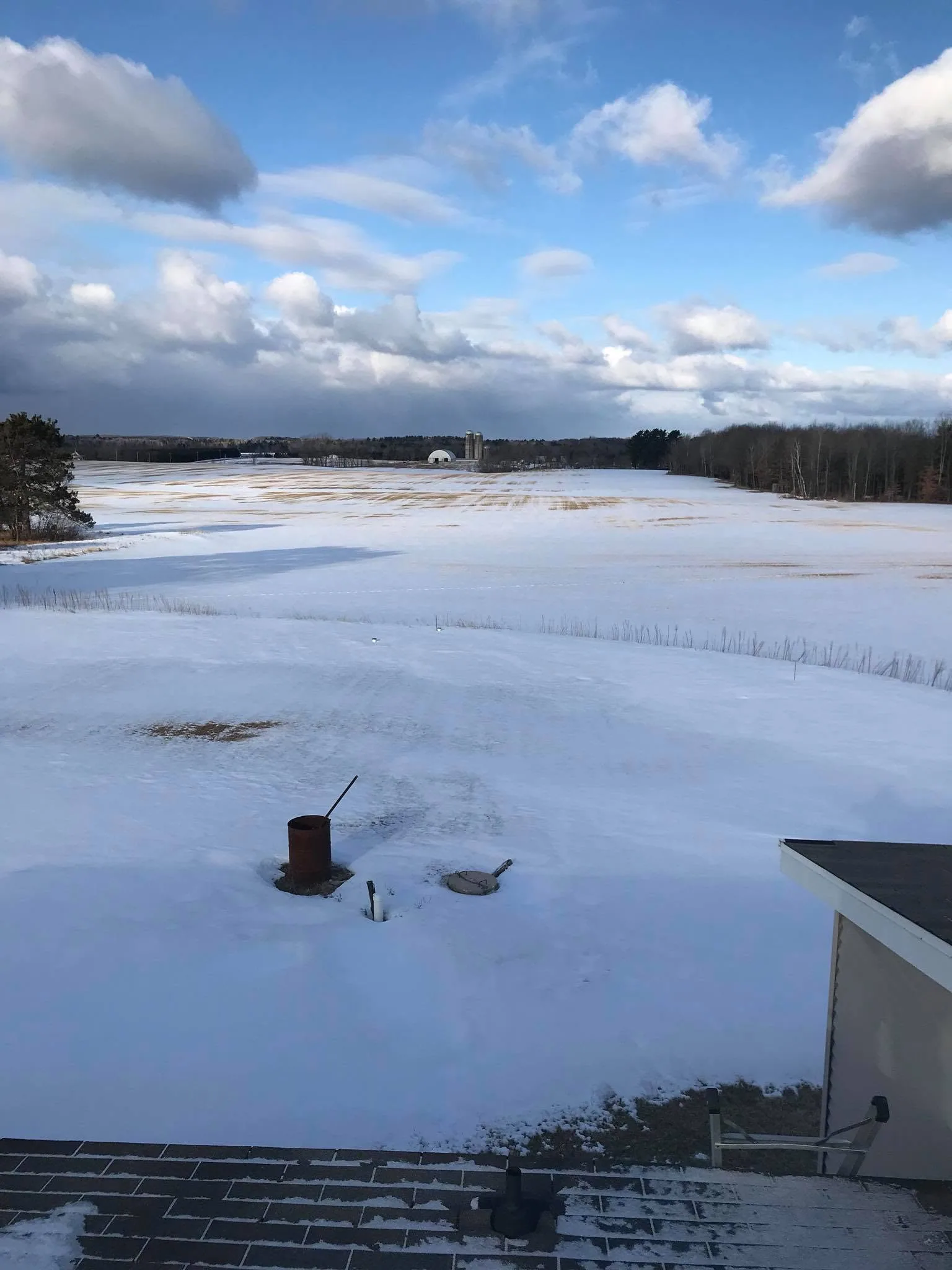 Septic well covers snowy yard view from roof