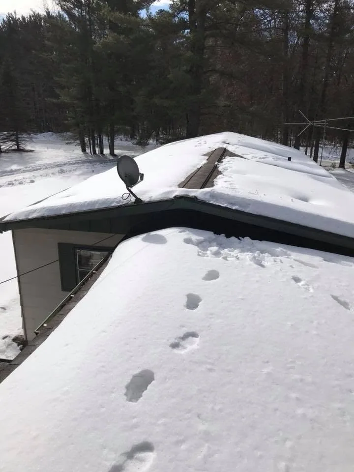 Snow covered roof footprints satellite dish