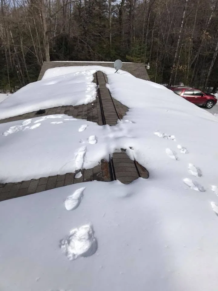 Snow covered roof ridge vent inspection