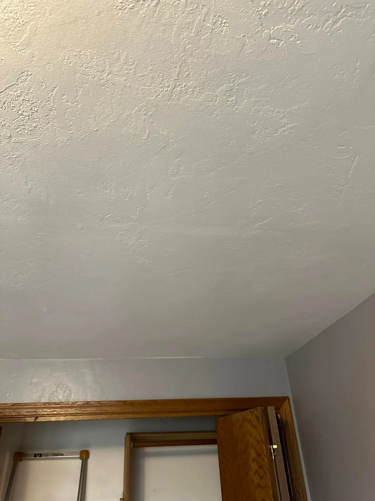 Textured ceiling above closet door faint water stain